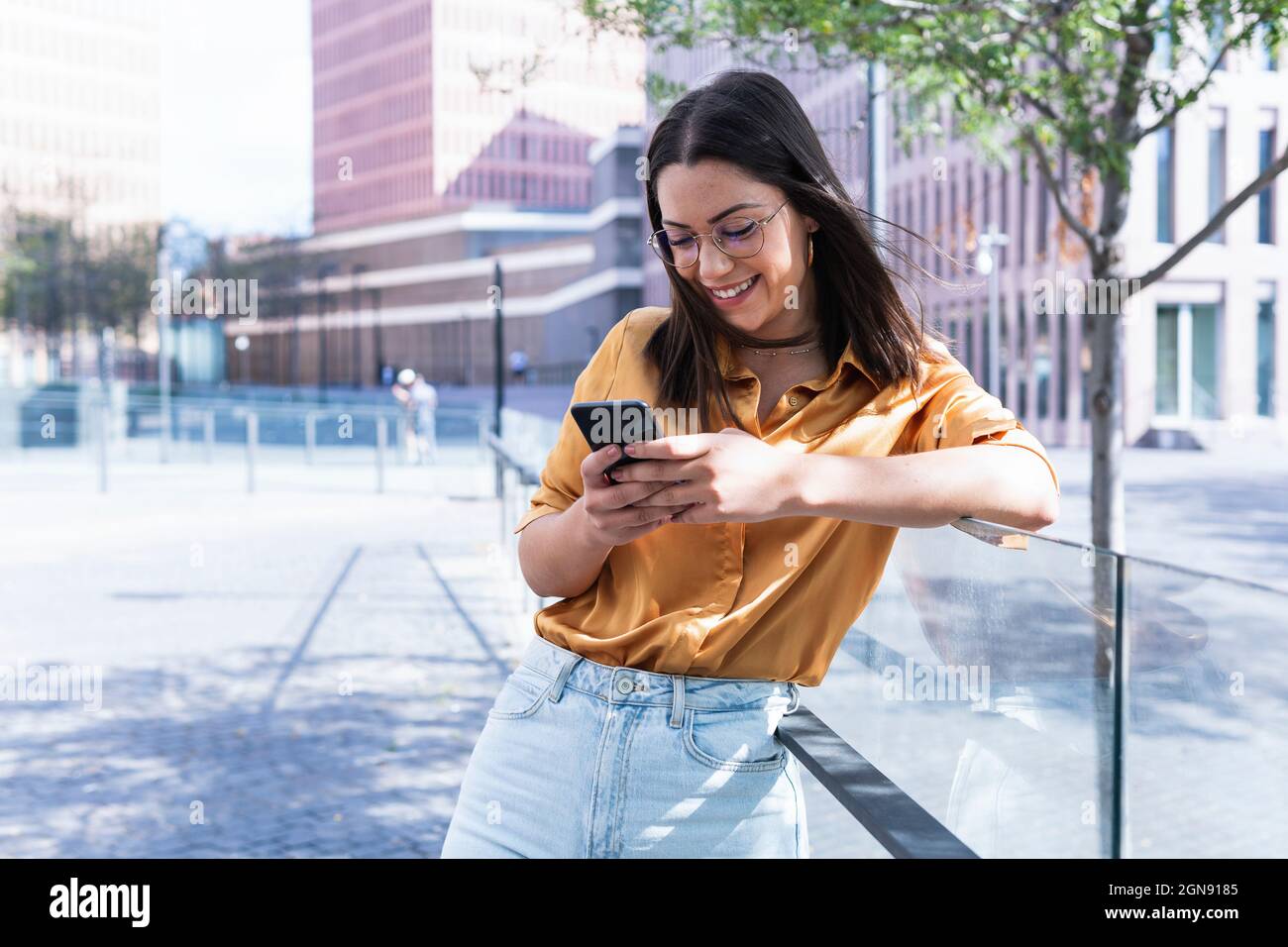 Texting Through Phone Smiling female professional text messaging through mobile phone while ...