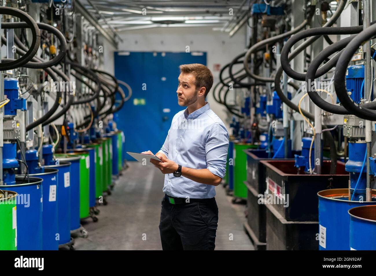 Male inspector checking production line in paint factory Stock Photo ...
