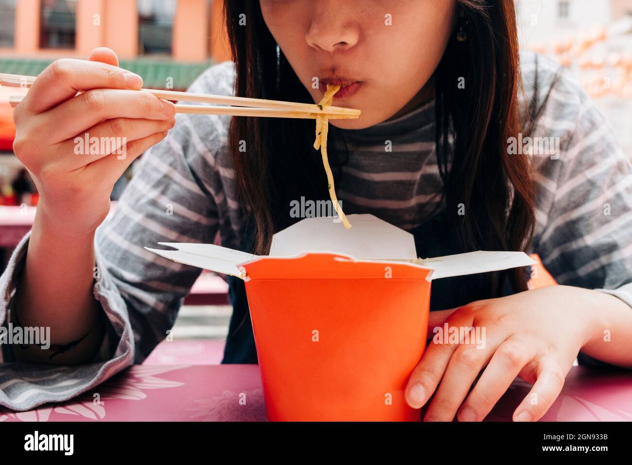 Woman eating noodles with chopsticks Stock Photo