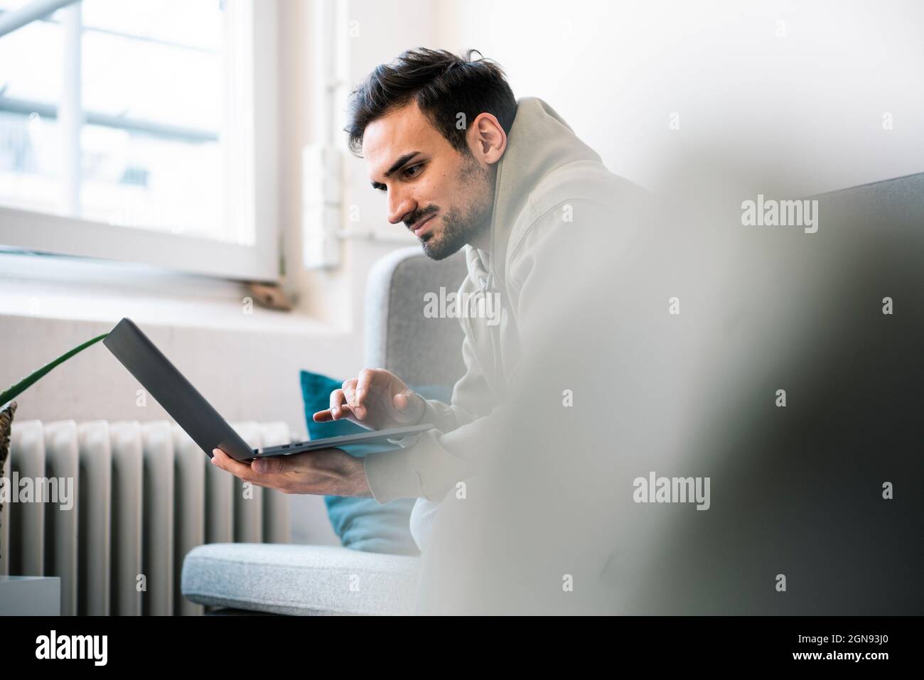 Young businessman using laptop while sitting in office Stock Photo