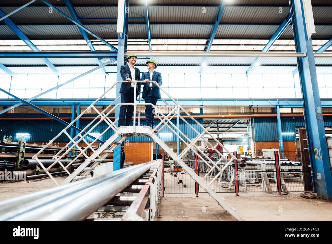 Businessman standing with warehouse worker in industry Stock Photo