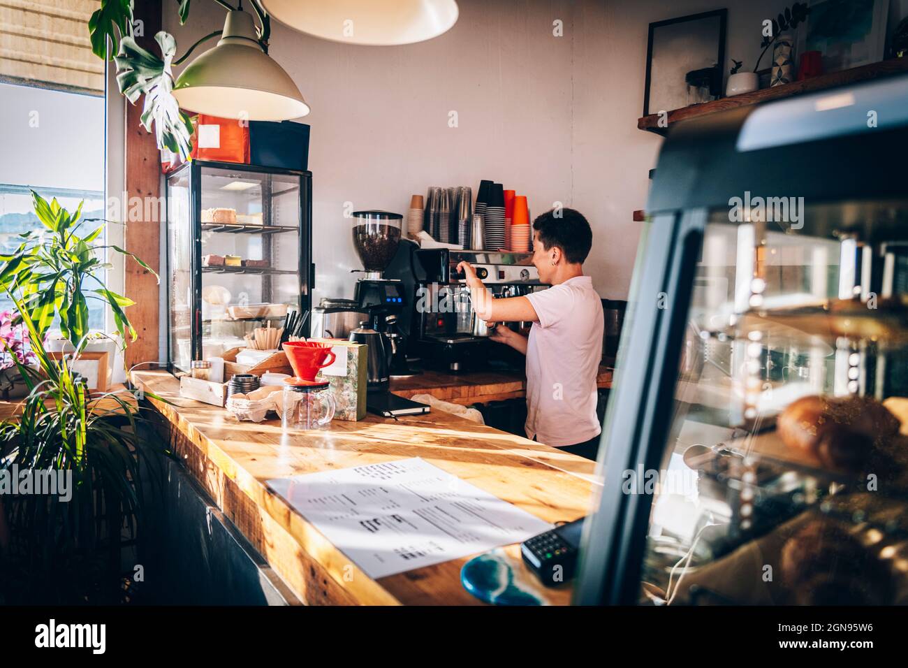 Female barista making coffee while working in cafe Stock Photo