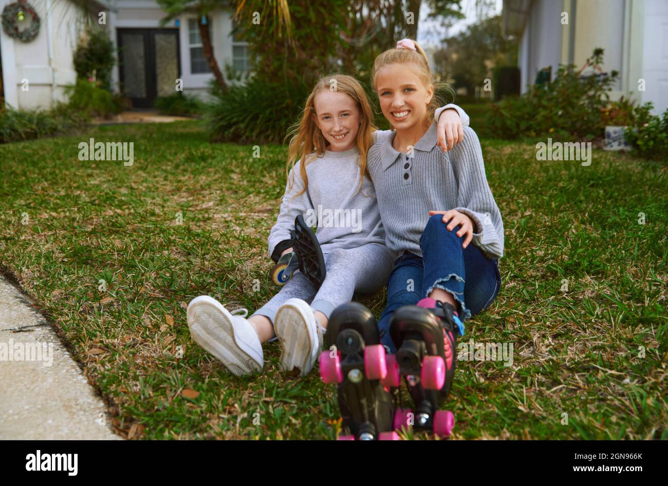 Smiling girls sitting on grass Stock Photo
