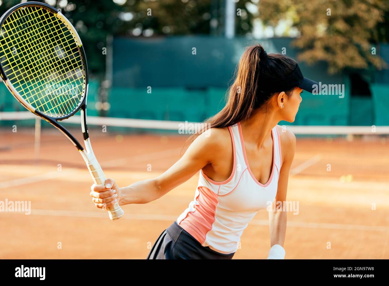 Female sportsperson playing tennis at sports court Stock Photo