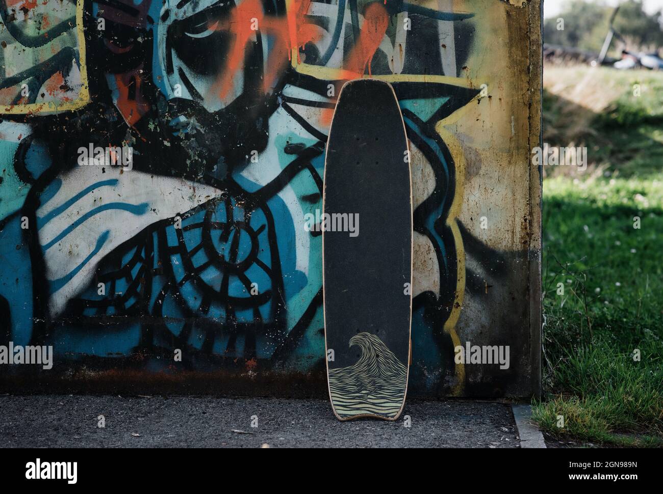 skateboard leaning against a wall at a skatepark in the UK Stock Photo