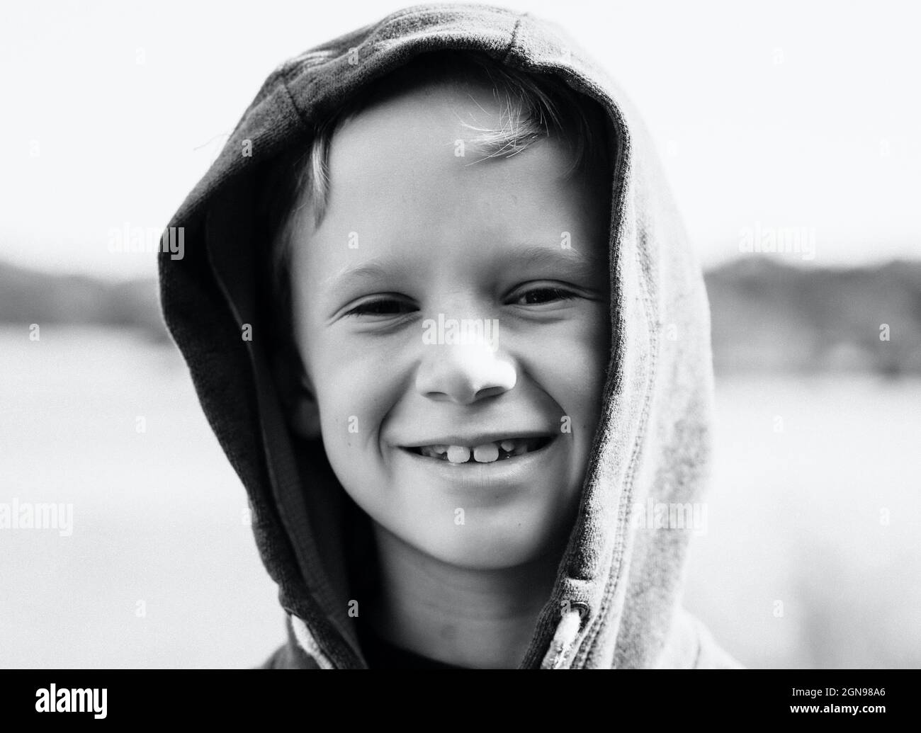 portrait of a boy smiling with his hood up at the beach Stock Photo Alamy