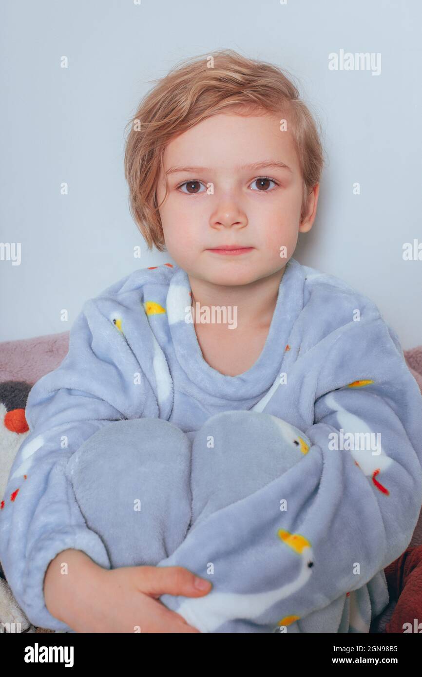 5 years old boy in pajamas sitting on the bed with toys Stock Photo Alamy