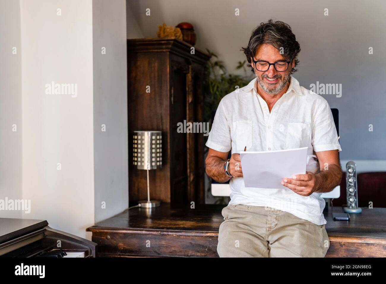 Male freelancer checking documents while working at home office Stock Photo