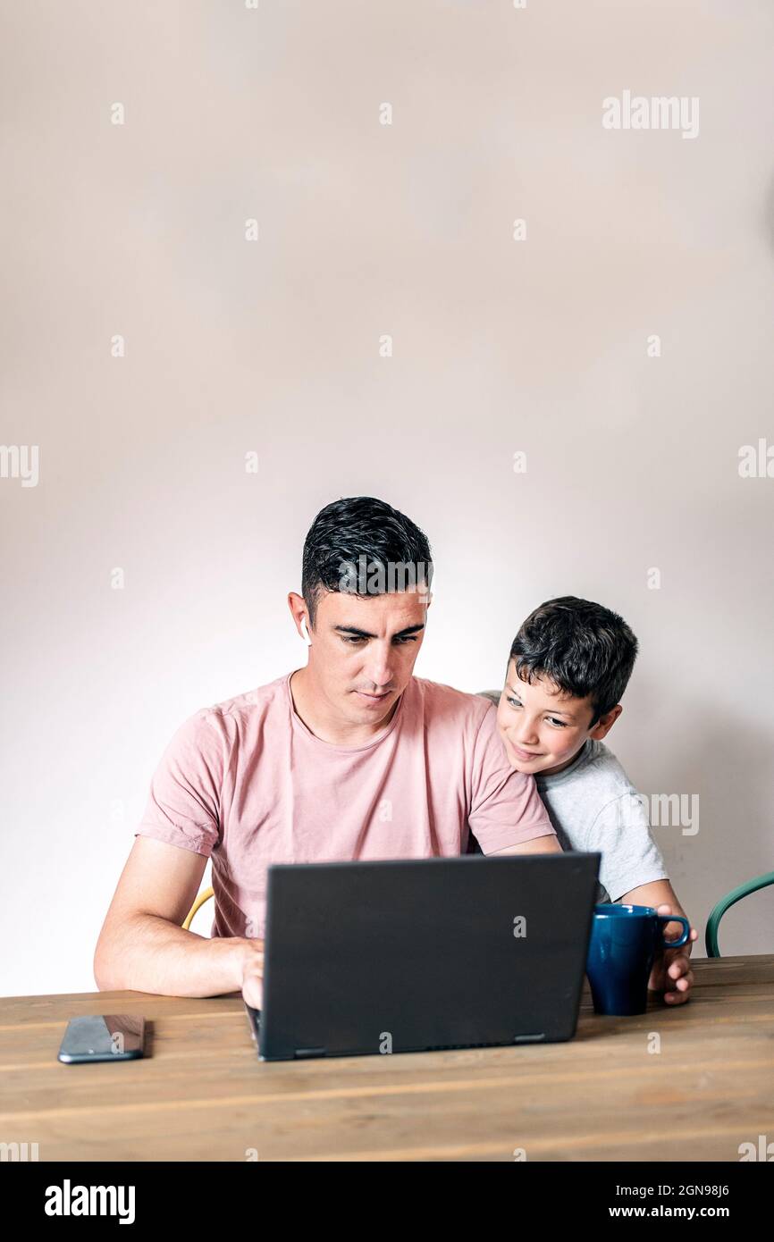 Freelance in casual clothes browsing laptop working on a project Stock Photo