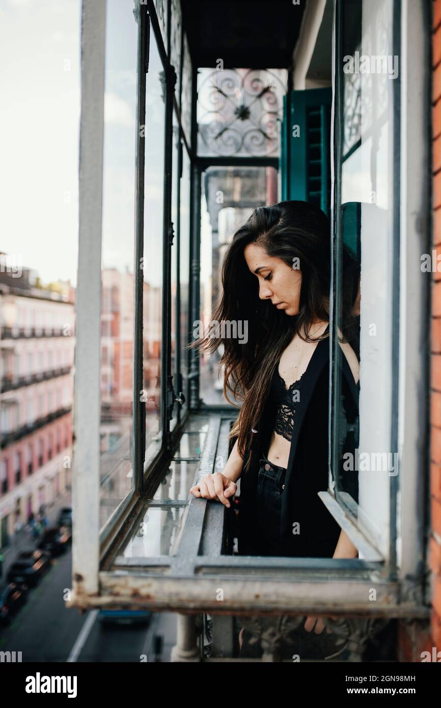 Sad woman standing at window Stock Photo