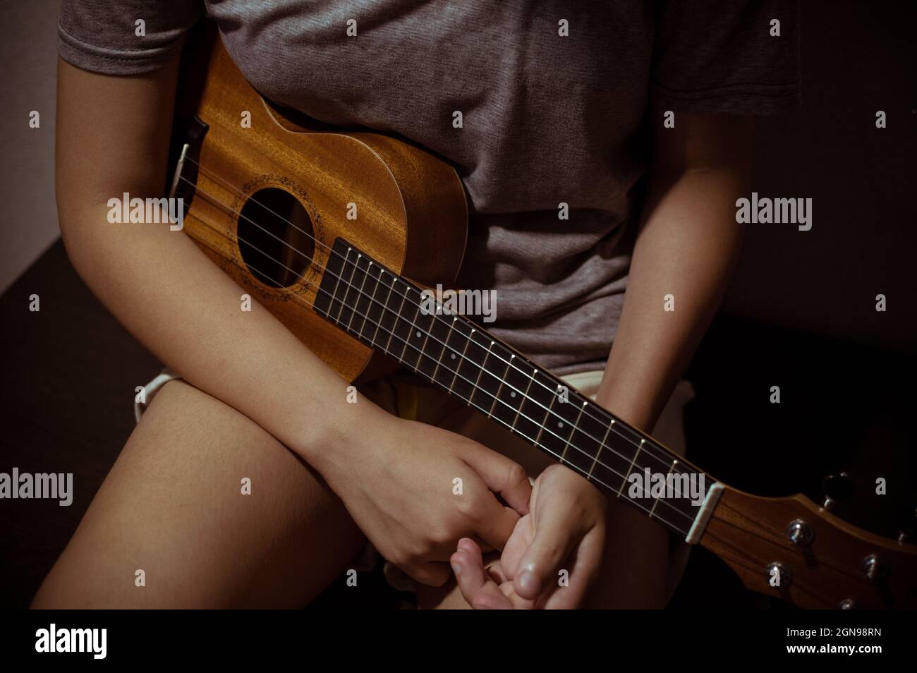 Wooden ukulele in the hands of a girl, closeup Stock Photo Alamy