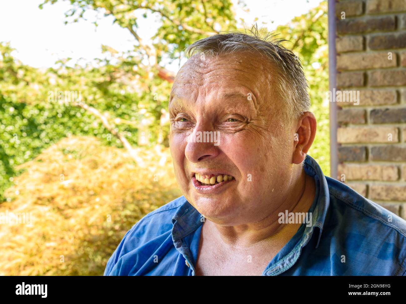 Portrait of tired mature man with grimace facial expression outside. Stock Photo