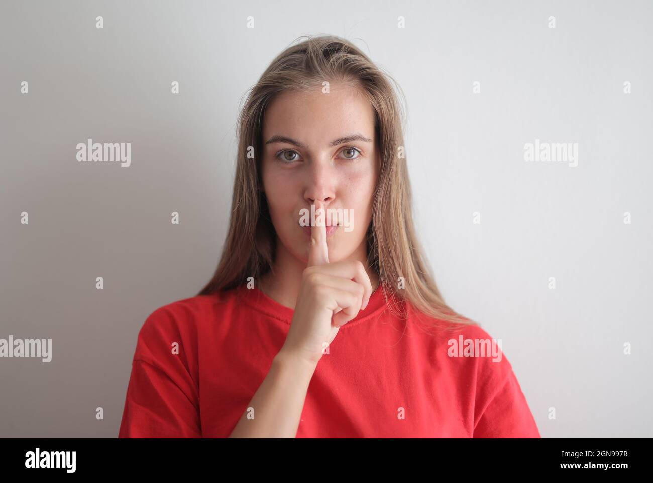 portrait of young woman with silence gesture Stock Photo