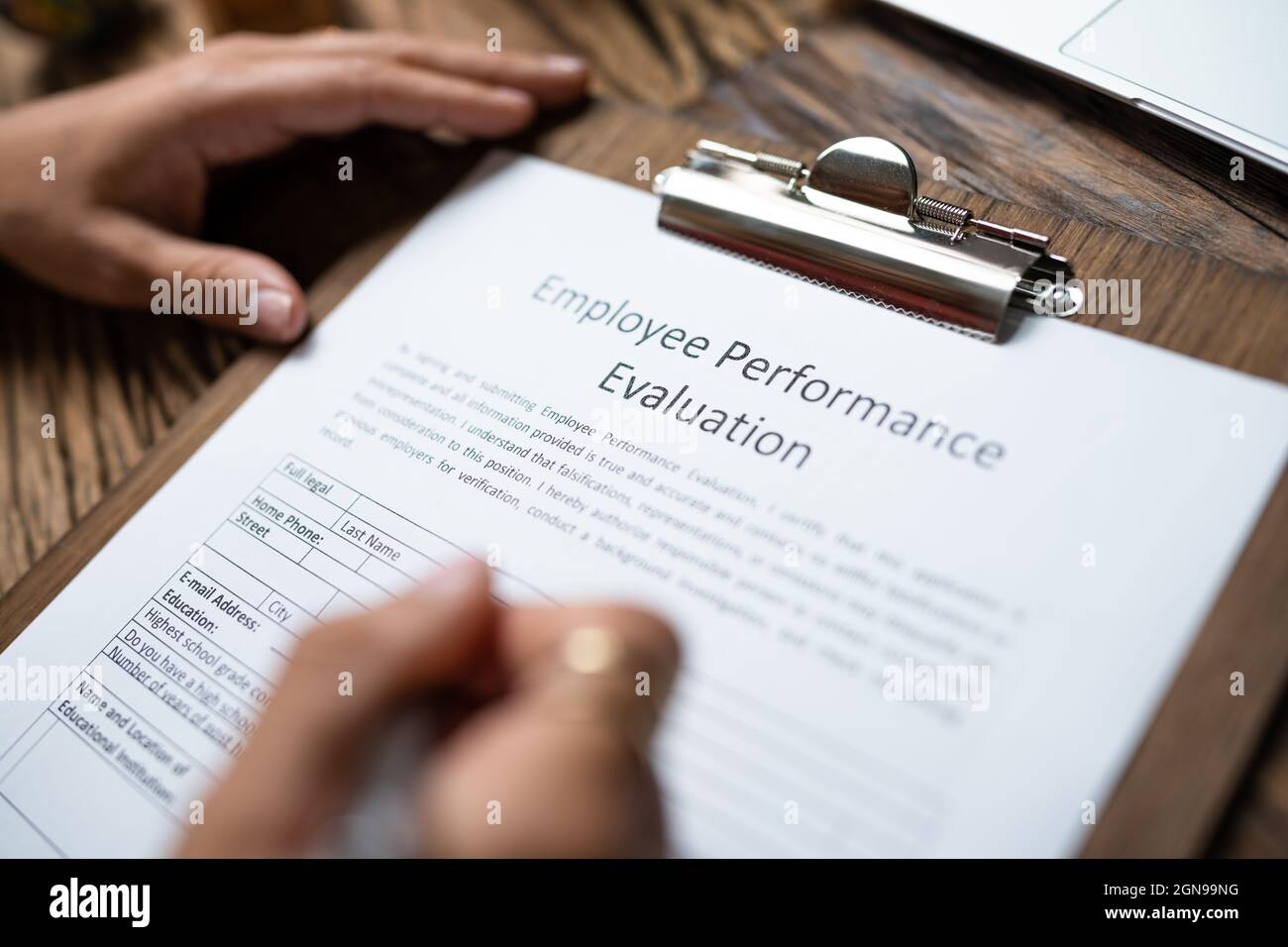 Person Filling A Performance Evaluation Form Of Employee Stock Photo