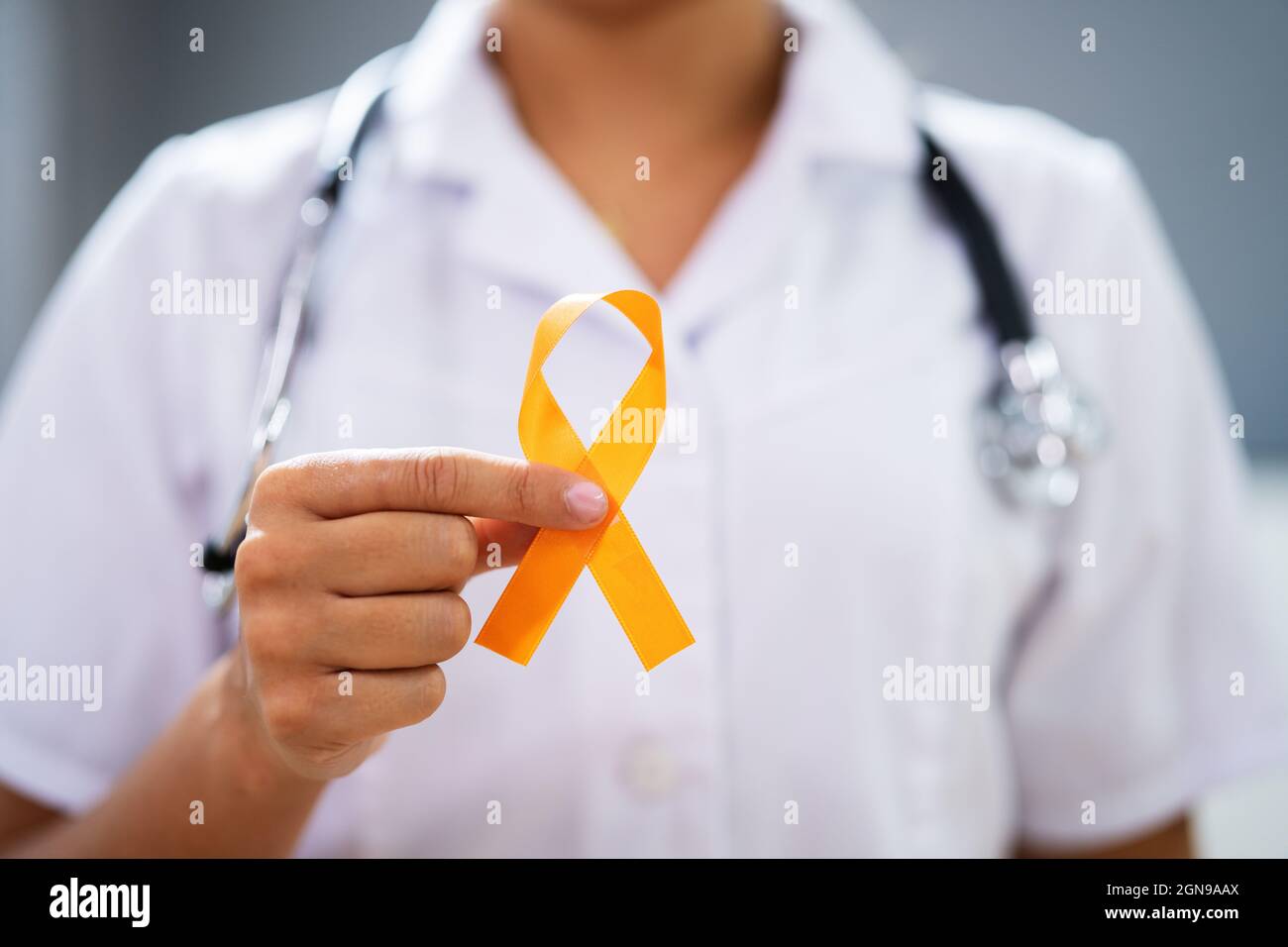 Female Doctor's Hand With Ribbon Showing Uterine Cancer Awareness Stock Photo