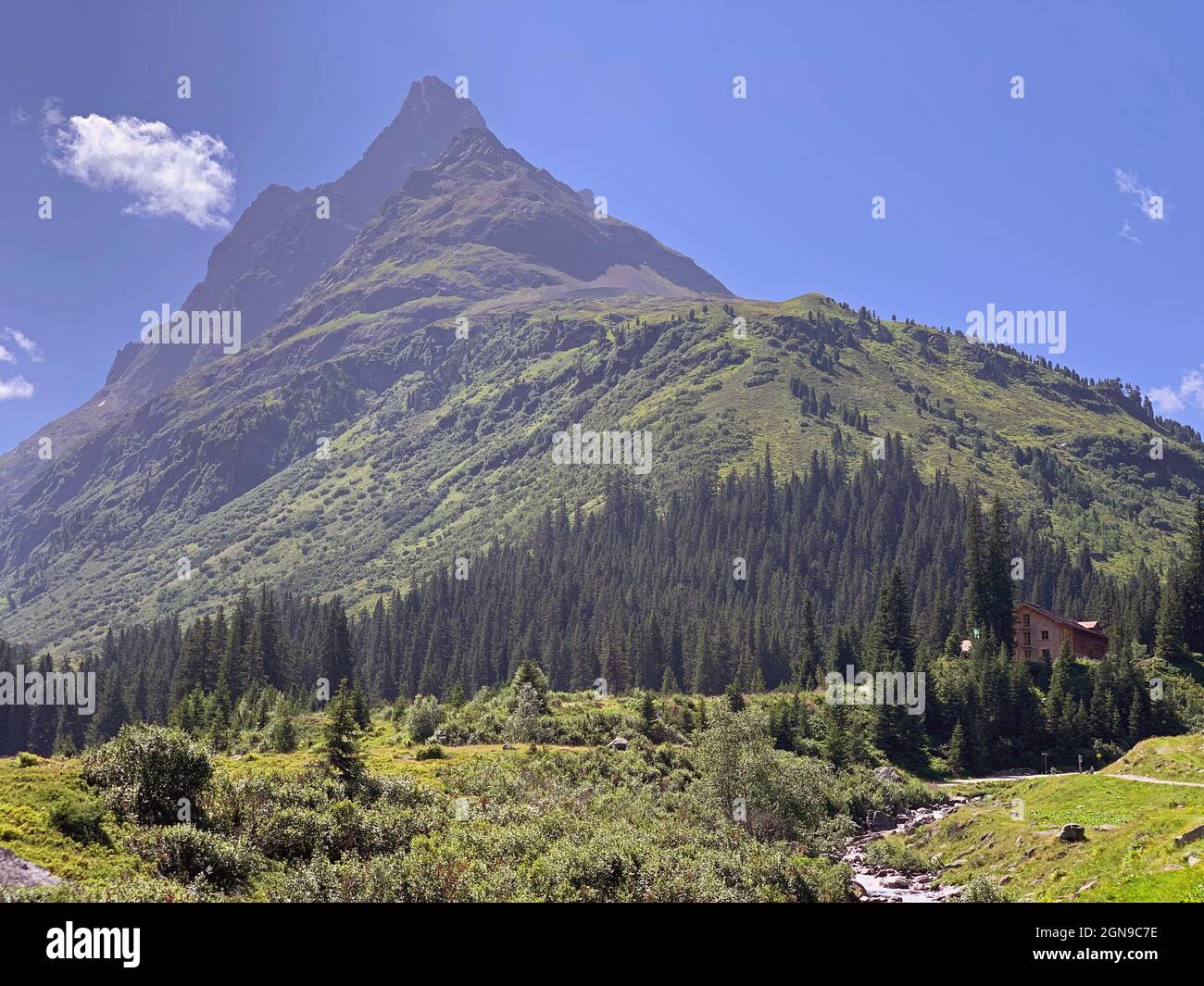 The majestic peak with the flowing river and Konstanzer Hutte shelter in Austria Stock Photo