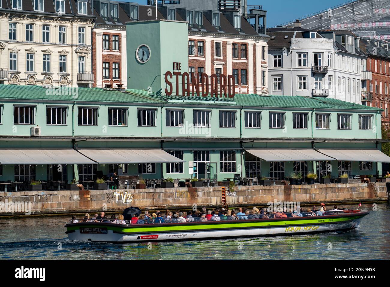Former customs house, now restaurants, The Standart, on the harbour, canal cruise boat, Copenhagen, Denmark, Stock Photo