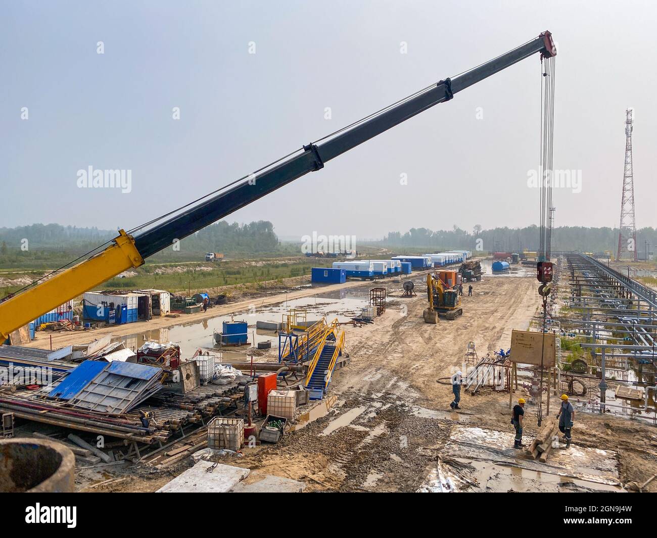 Oil industry. Sorting of drilling tools, pipes by diameter, re-laying. Working with a crane. Stock Photo