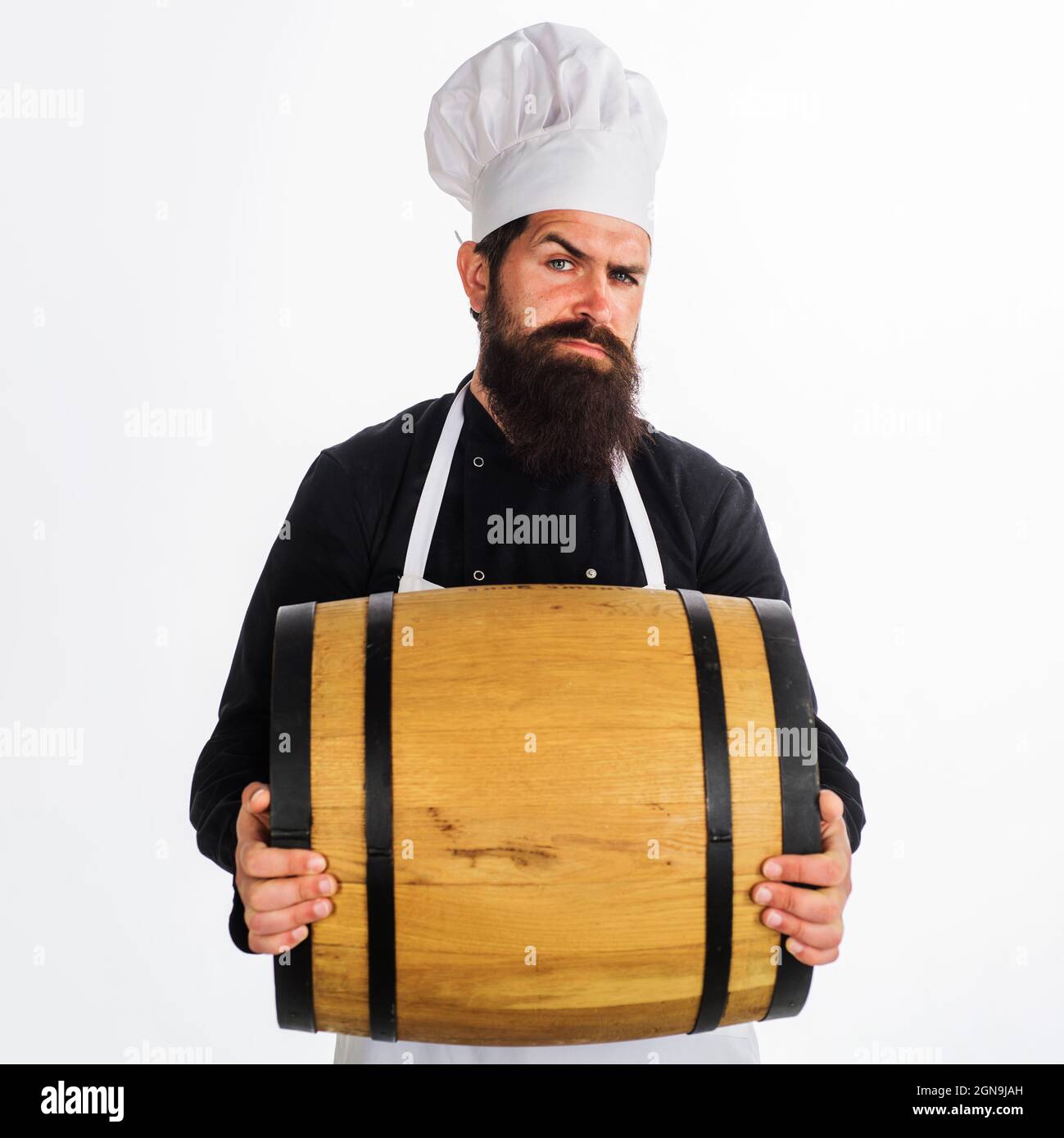 Male Chef with Wooden barrel with beer. Oktoberfest. Bearded man carry wooden barrel with wine. Homemade wine. Stock Photo