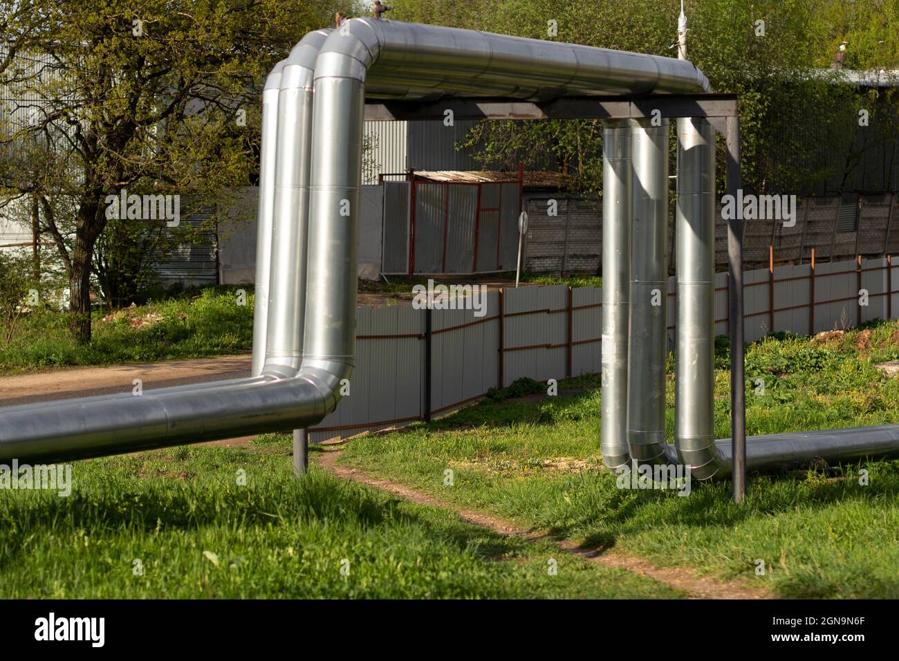 Heating pipes on the surface. Hot water supply. The heating main is covered with stainless steel. Stock Photo