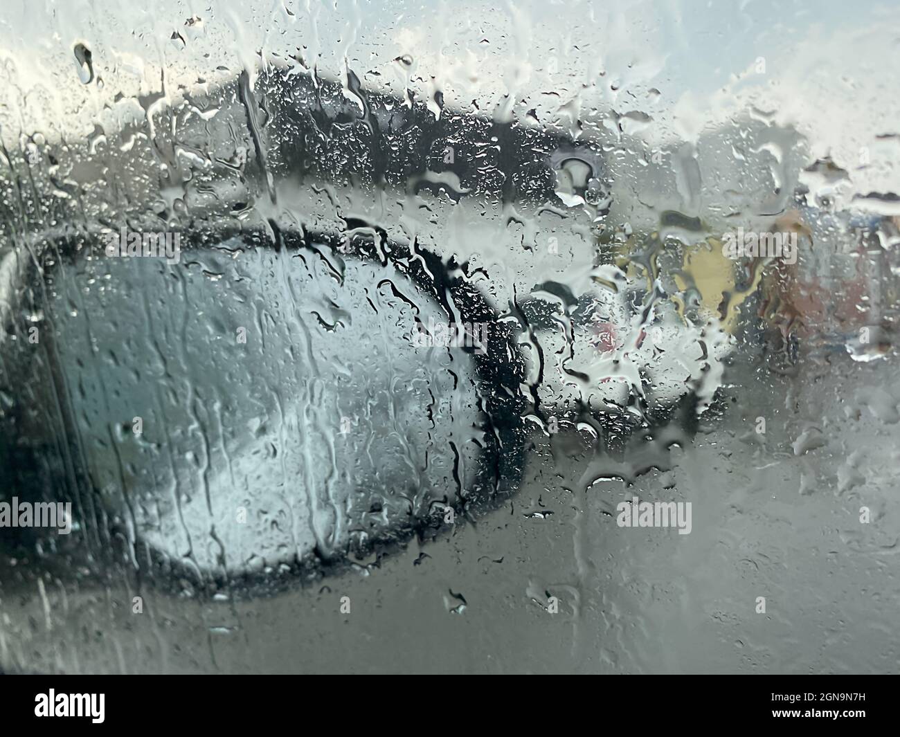Raindrops on the car window on the background of the mirror Stock Photo