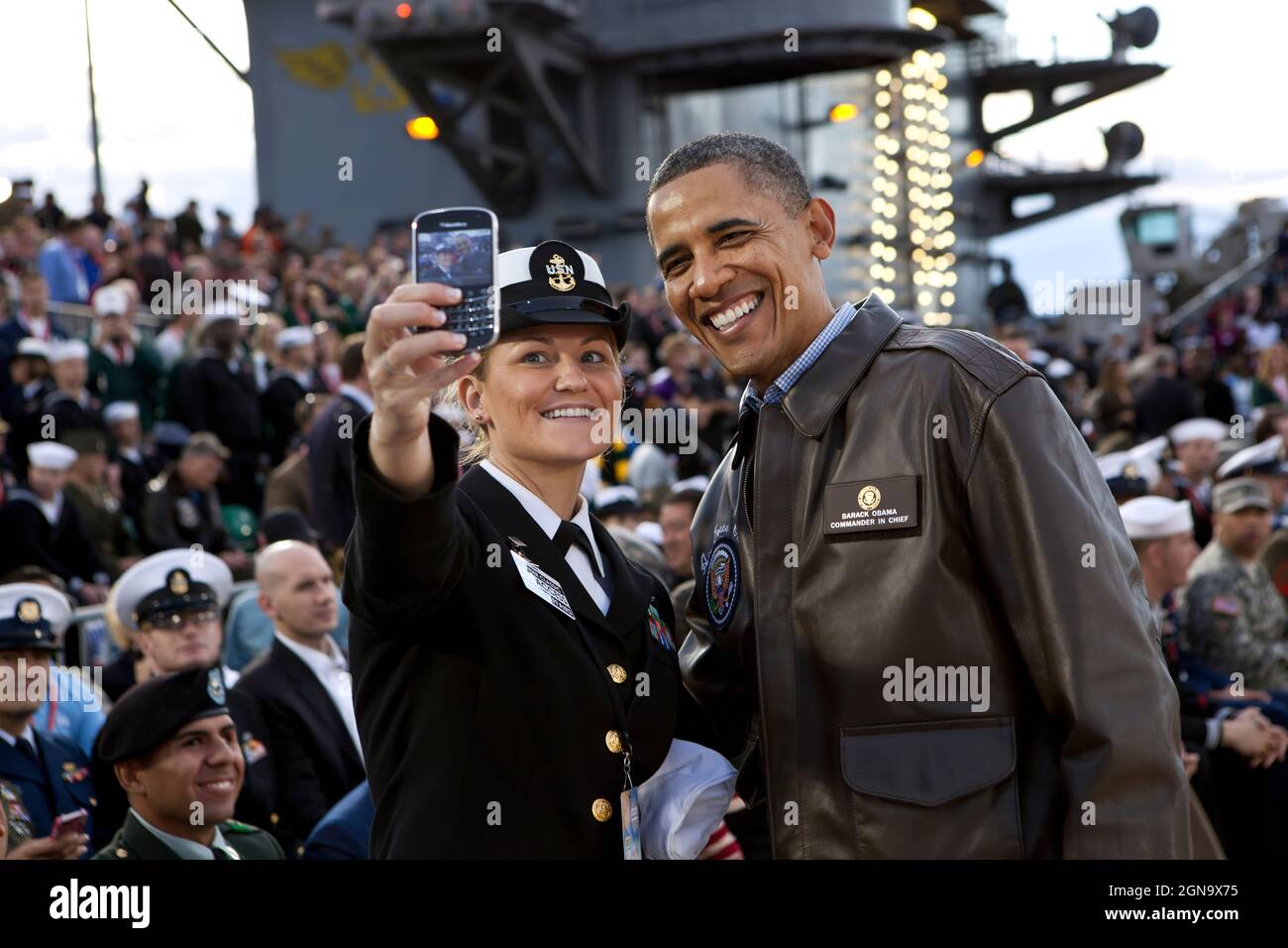 President Barack Obama has his picture taken with a member of the U.S. Navy on the flight deck of the USS Carl Vinson, docked at North Island Naval Station in San Diego, Calif., Nov. 11, 2011. (Official White House Photo by Pete Souza)  This official White House photograph is being made available only for publication by news organizations and/or for personal use printing by the subject(s) of the photograph. The photograph may not be manipulated in any way and may not be used in commercial or political materials, advertisements, emails, products, promotions that in any way suggests approval or Stock Photo