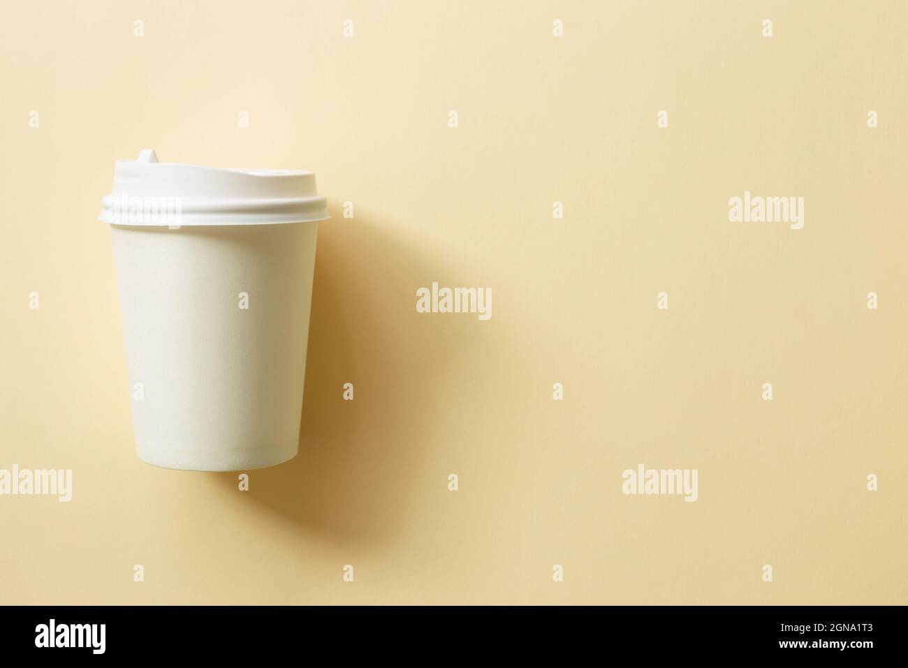 White paper coffee cup on beige background. top view, copy space Stock Photo