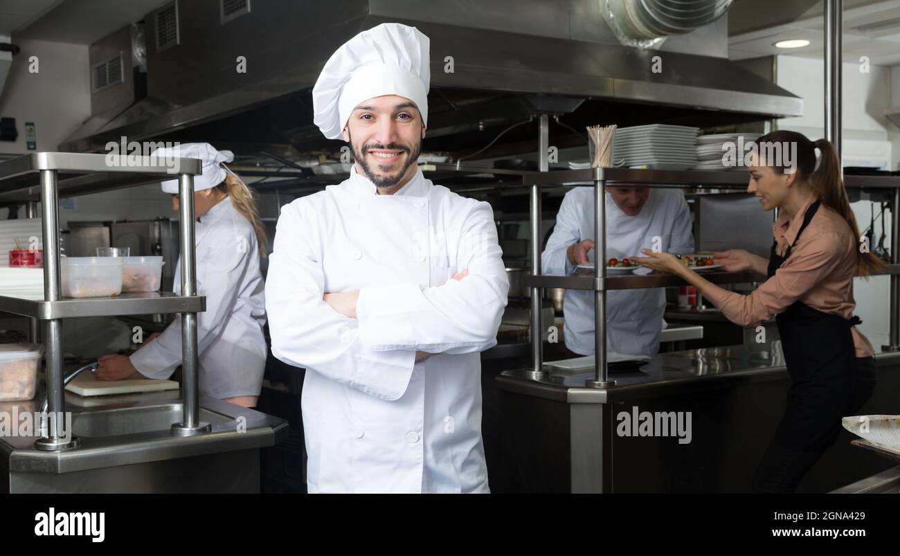 Chef in kitchen with busy staff Stock Photo