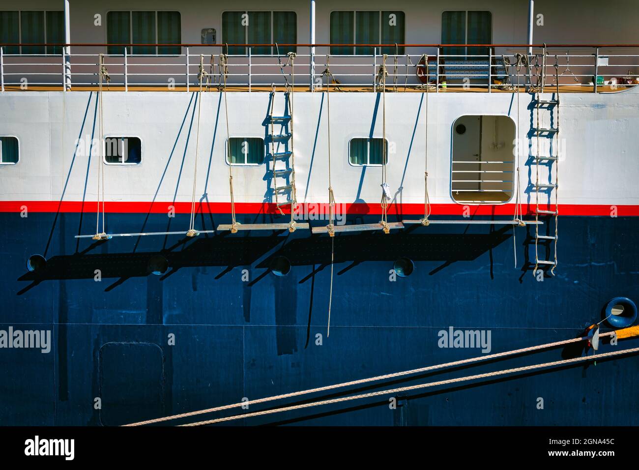 Scaffolding hangs on the side of a cruise ship in the process of being repainted and docked in Yokohama, Japan. Stock Photo