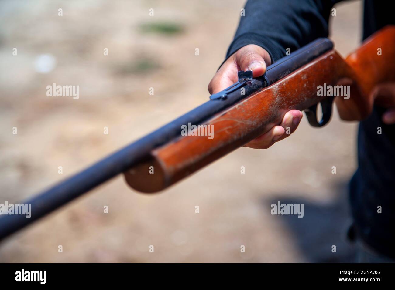 person holding an old vintage gun made of wood Stock Photo