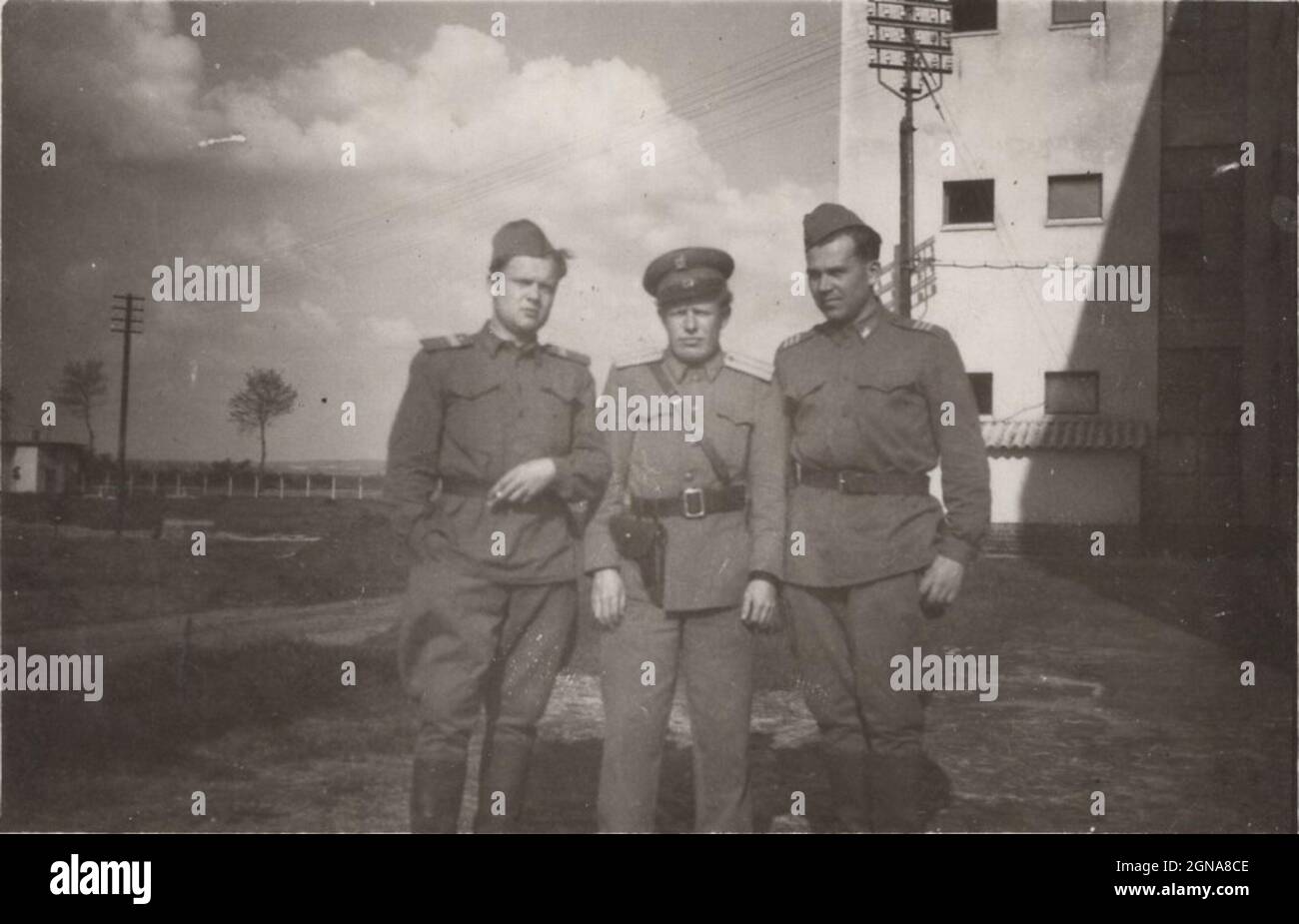 a Proud father ( who is Policeman / police officer) stands with his two cadet sons whose were spending them mandatory time at the Hungarian army in the 1950's. Military service period was 3 years at this time. / vintage man smoking a cigarette Stock Photo