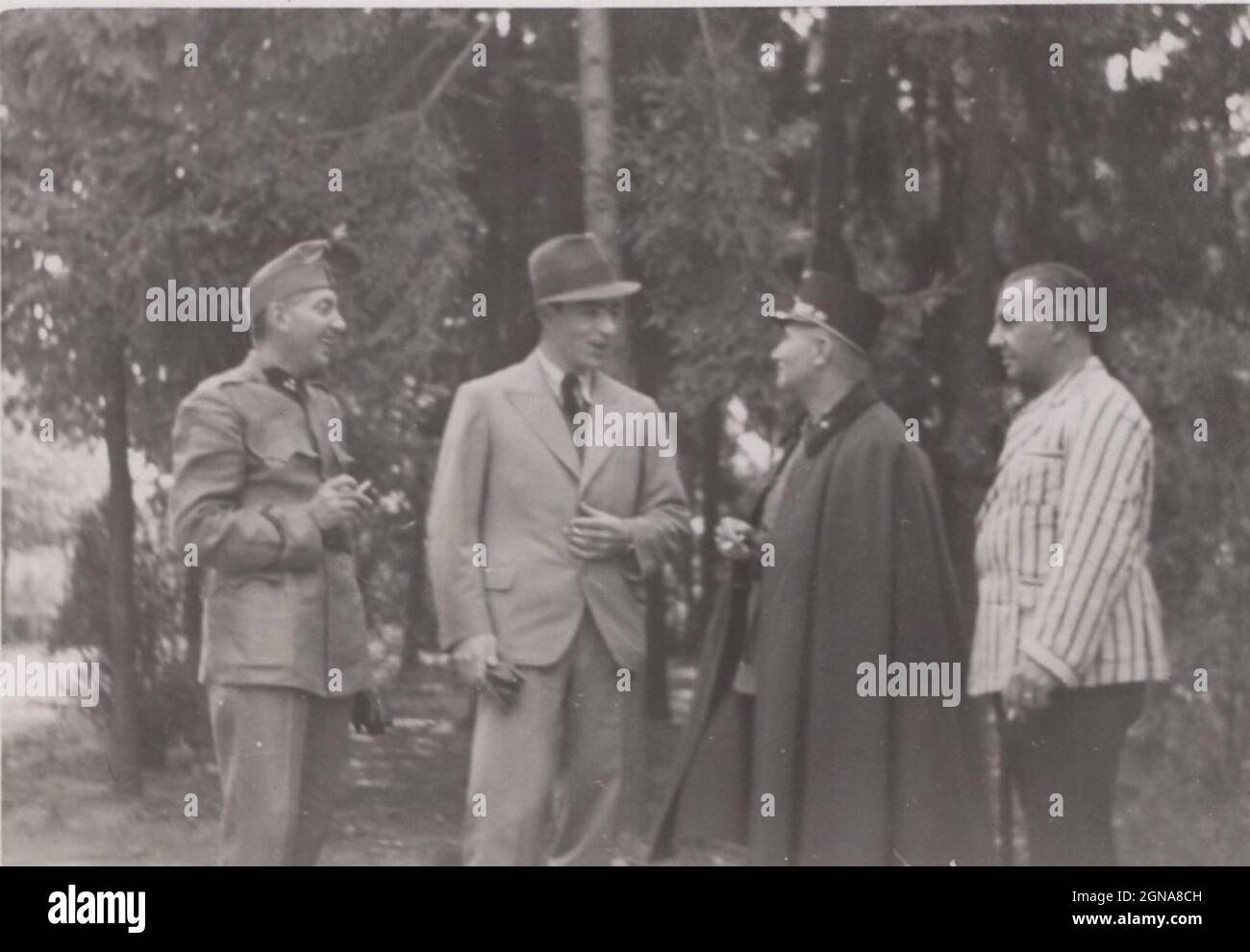 High ranking military officer meets with civilians in the forest. The well dressed person could be the owner of the wood or any nobleman, or  VIP ( very important person) or any politician.  They met in a silent place amoung 10 eyes. Place: forest. Country: Kingdom of Hungary. Period: 1920's, Source: original photograph / vintage man smoking a cigarette Stock Photo