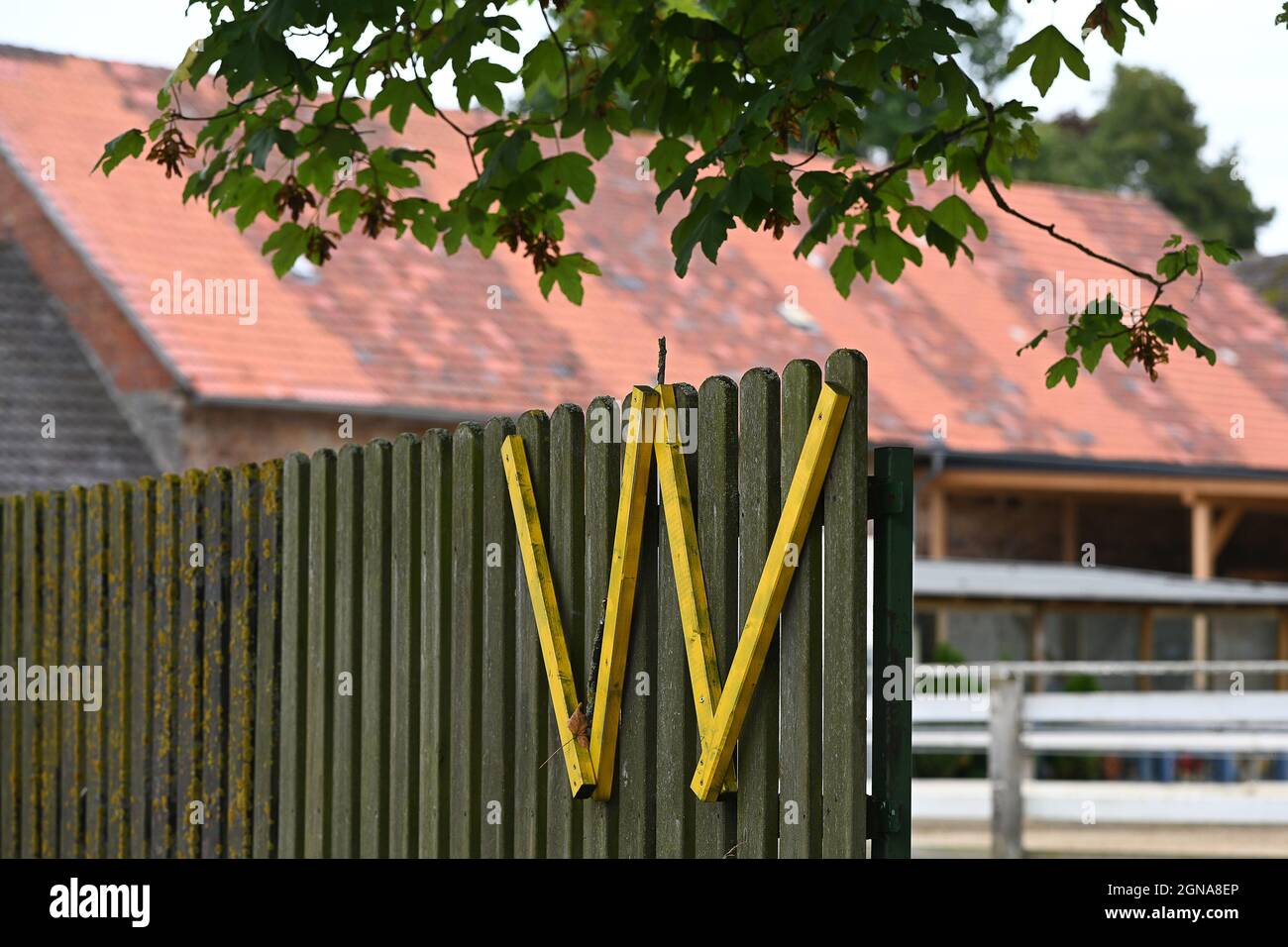 PRODUCTION - 20 September 2021, North Rhine-Westphalia, Würgassen: A yellow 'W' symbol hangs on a fence. The Gesellschaft für Zwischenlagerung (BGZ) is planning a logistics centre for low- and intermediate-level radioactive waste for the Konrad repository in Lower Saxony on the site of the former Würgassen nuclear power plant. Photo: Swen Pförtner/dpa Stock Photo