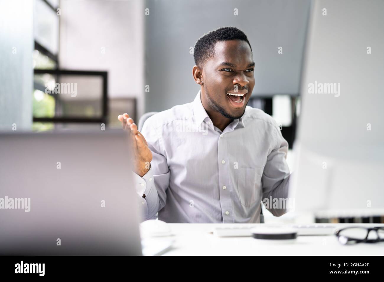 Shocked African Man With Ransomware On Office Computer Stock Photo