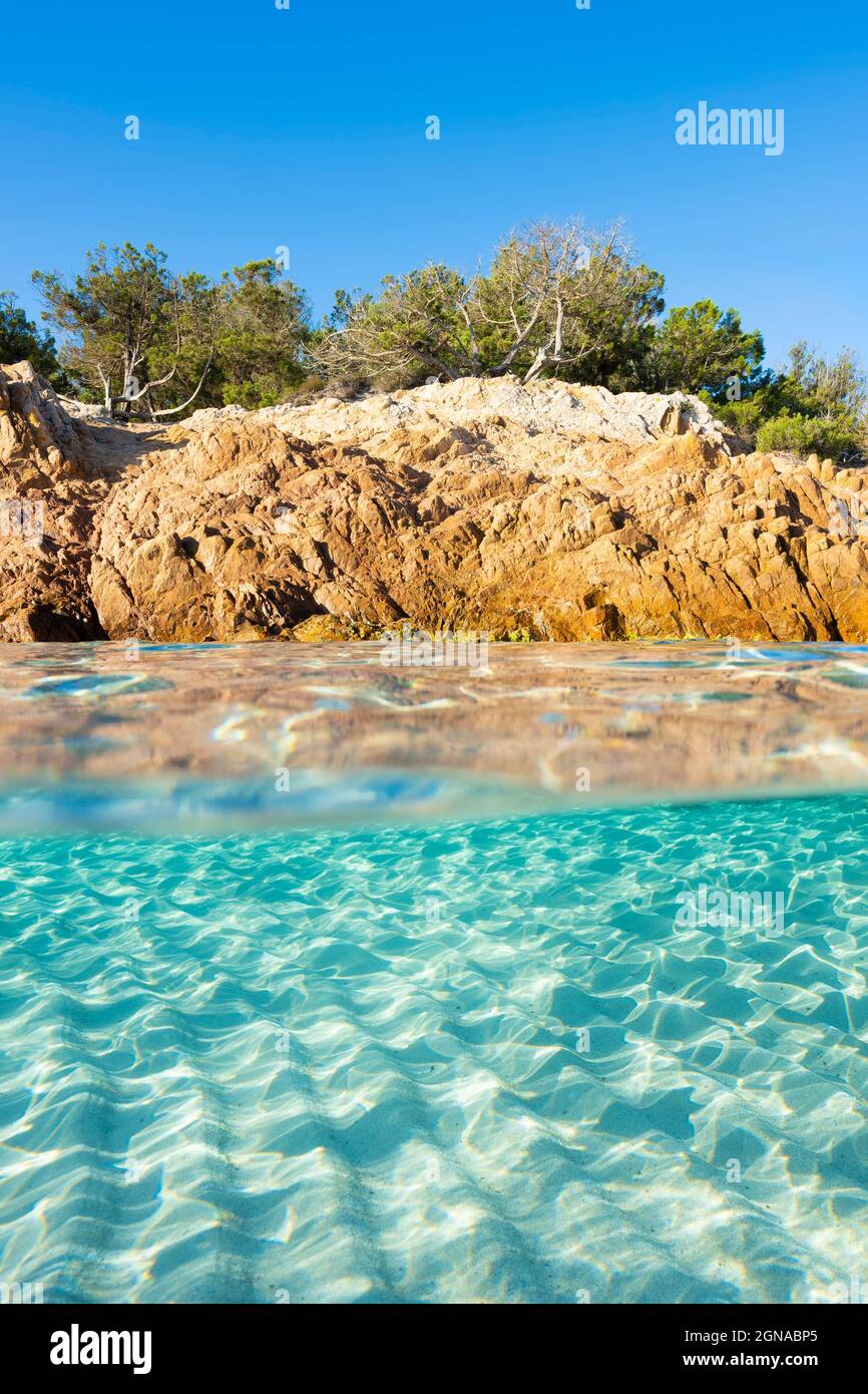 Split shot, over under photo. Half underwater with turquoise water and a rocky coast on the water surface. Prince Beach (Spiaggia del Principe) Stock Photo
