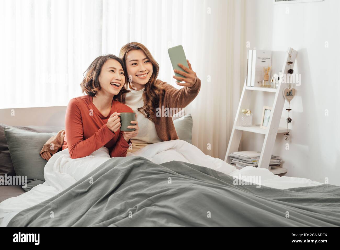 two girls taking a selfie while having lazy weekend at home Stock Photo