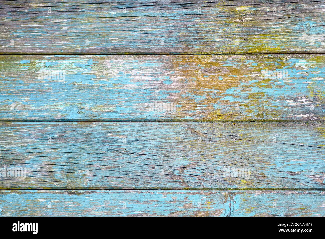 Horizontal wooden planks background with teal blue and yellow colored old weathered planks with chipped paint Stock Photo