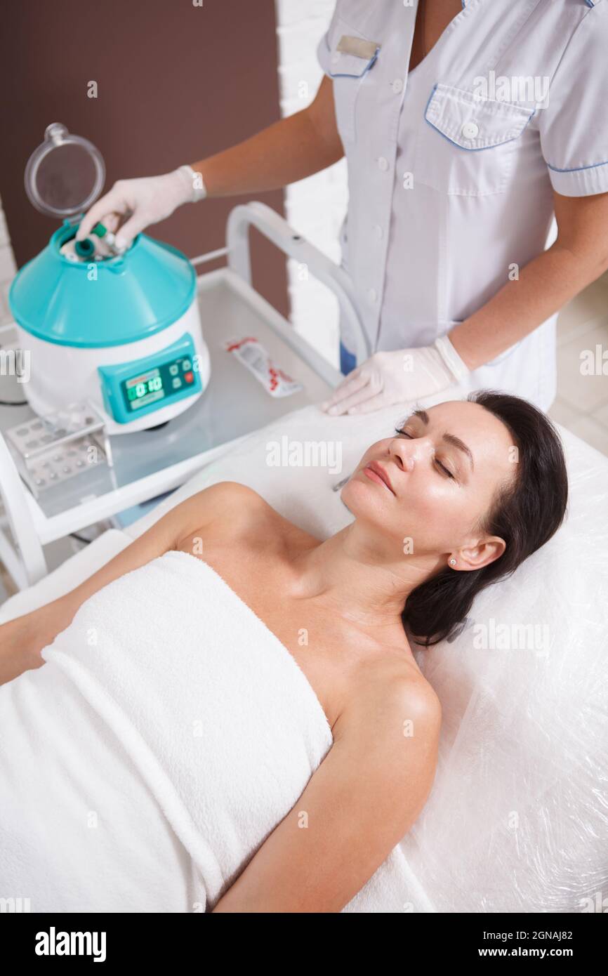 Vertical shot of a mature woman getting prp facial treatment by dermatologist Stock Photo