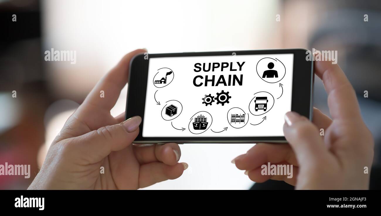 Hand holding a smartphone with supply chain concept Stock Photo