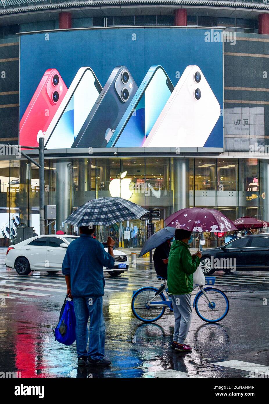 Beijing, China. 24th Sep, 2021. People walk past an apple store in Wangfujing with iPhone 13 series advertisement on a big screen. On September 24, 2021, the first batch of iPhone 13 series mobile phones are officially launched to be sold worldwide. Credit: SOPA Images Limited/Alamy Live News Stock Photo