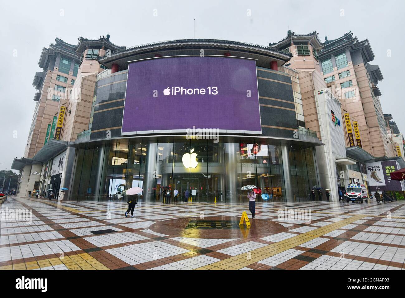 People walk past an apple store in Wangfujing with iPhone 13 series ...