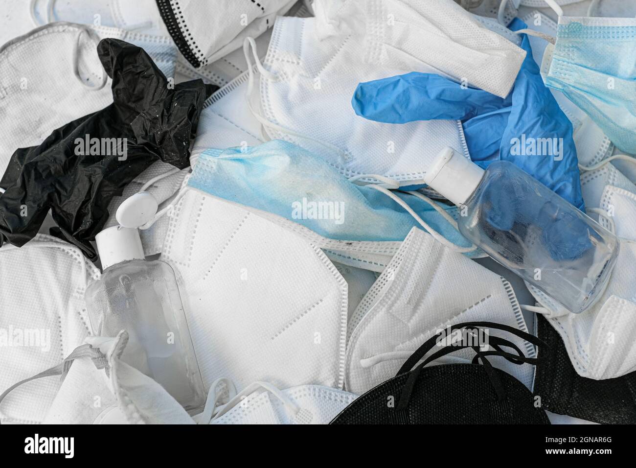 Pile of discarded used protective face mask,hand sanitizer bottle and gloves,covid19 pandemic waste pollution Stock Photo