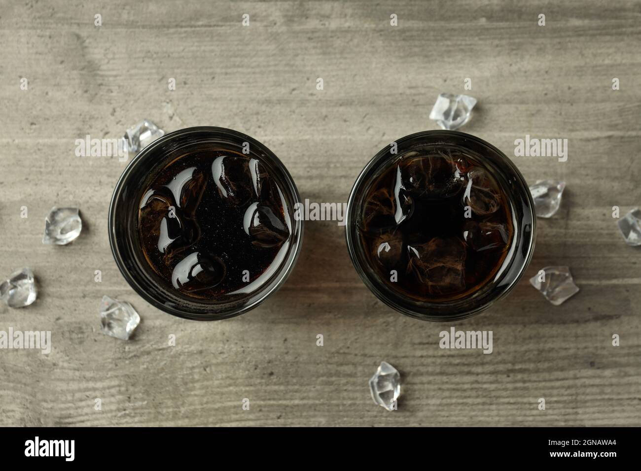 Glass of cola and ice on gray textured table Stock Photo - Alamy