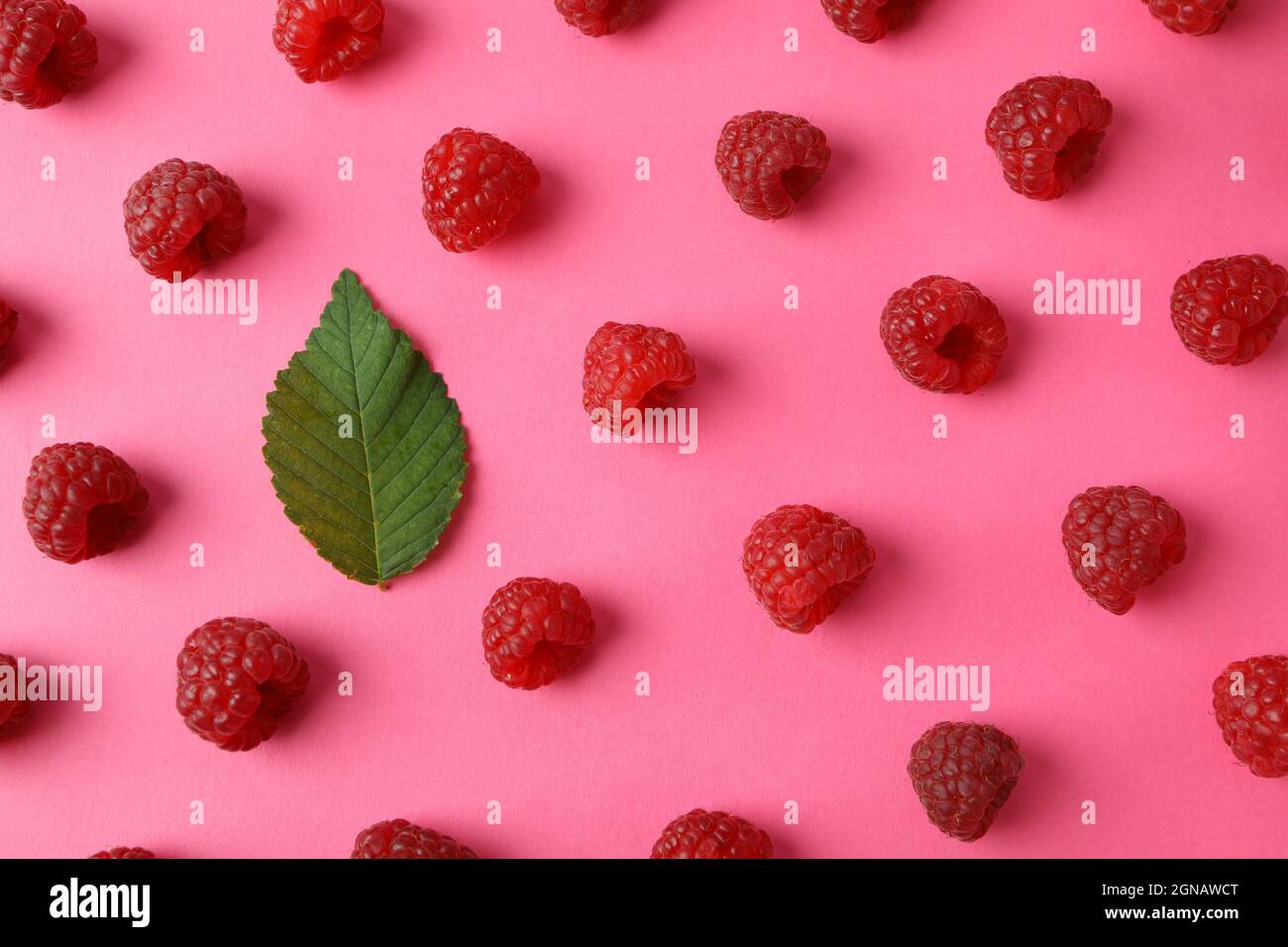 Raspberry Flat Lay Flat lay composition with red juicy raspberries and leaf on a pink ...