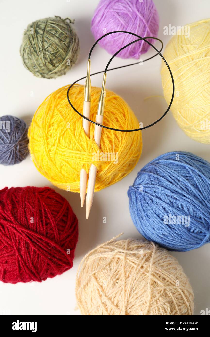 Balls of yarn with knitting needles on white background Stock Photo - Alamy