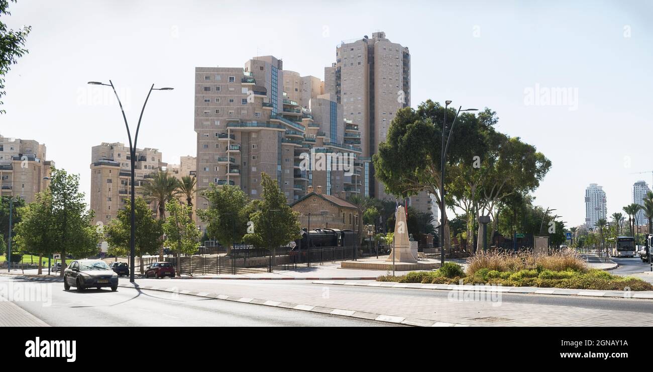 the small Ottoman era Turkish Train Station in Beer Sheva in Israel is surrounded by modern high rise buildings and avenues with a pale blue sky Stock Photo