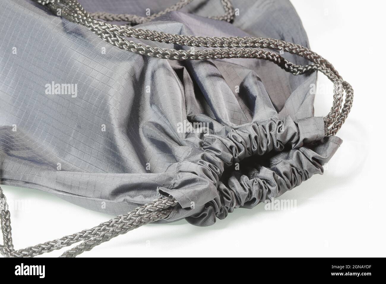 Close up gray drawstring bag or backpack with laces,  Sport bag isolated on white background. Stock Photo