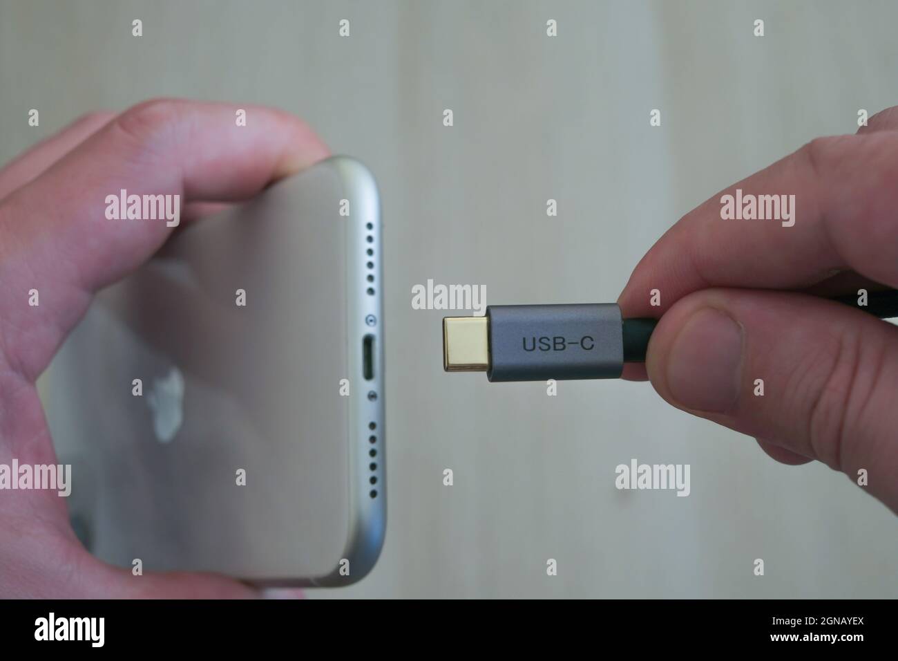 ISTANBUL TURKEY -27 September, 2021: Trying to put type-c on iphone. Hand holding type c or usb-c and iphone. Stock Photo