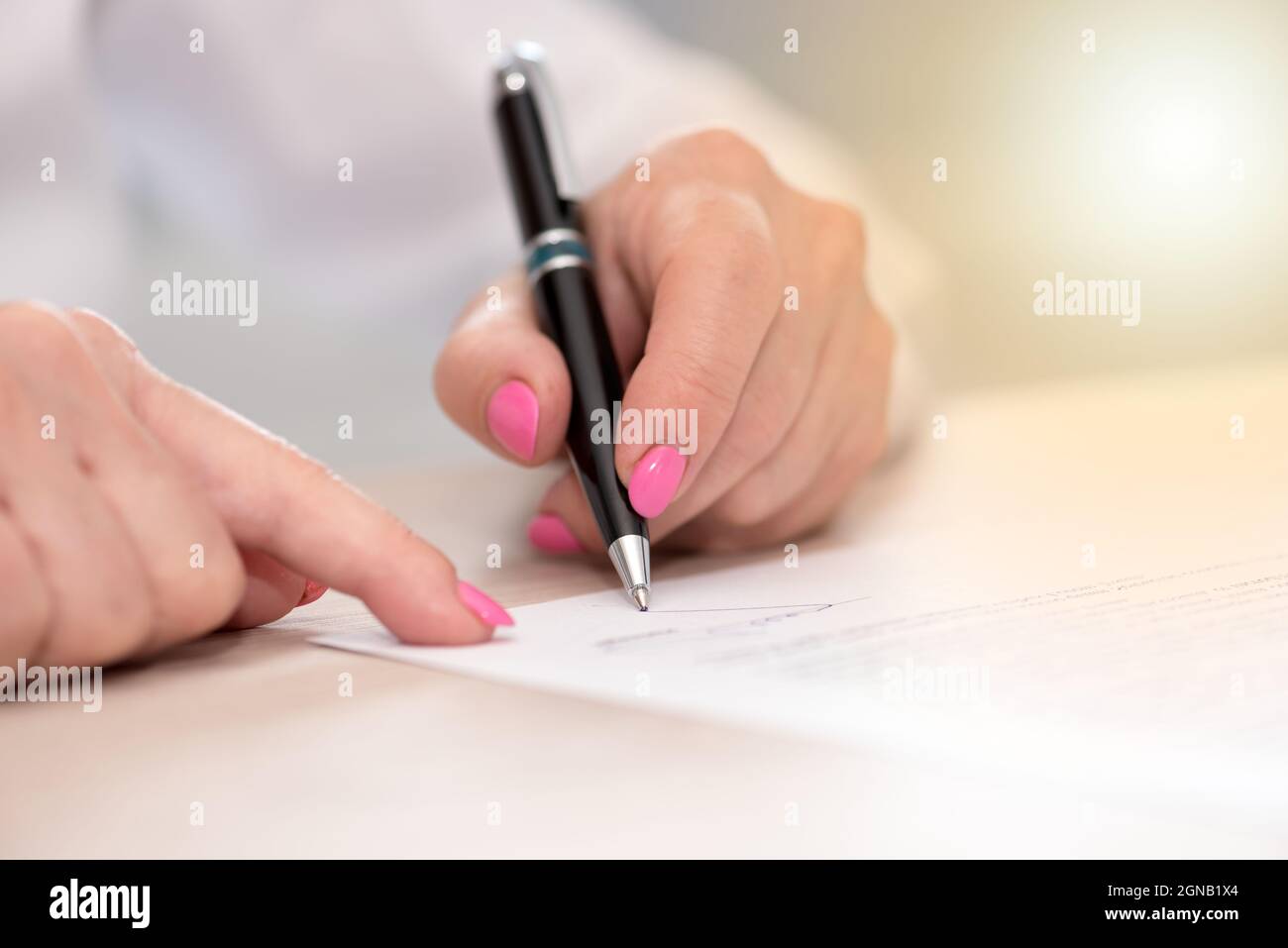 Woman signing a legal document, light effect Stock Photo - Alamy