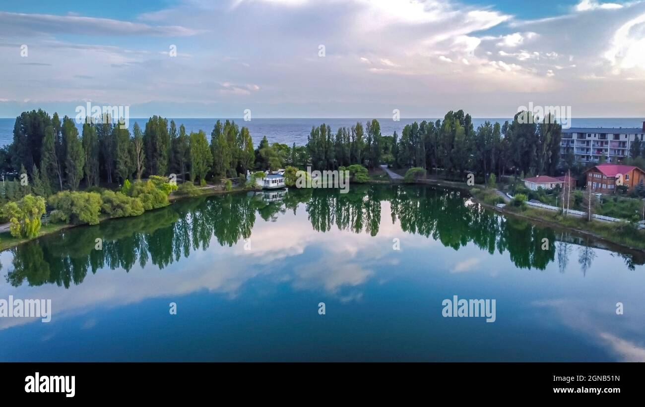 Issikul Idyllic summer landscape with lake near mountain with reflection from ...